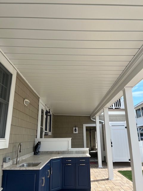 A kitchen with blue cabinets and a white counter top under deck