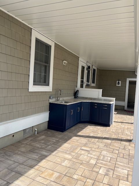 A kitchen with blue cabinets and a sink under the deck