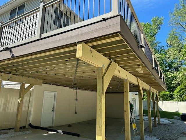 A wooden deck is being built on top of a garage.