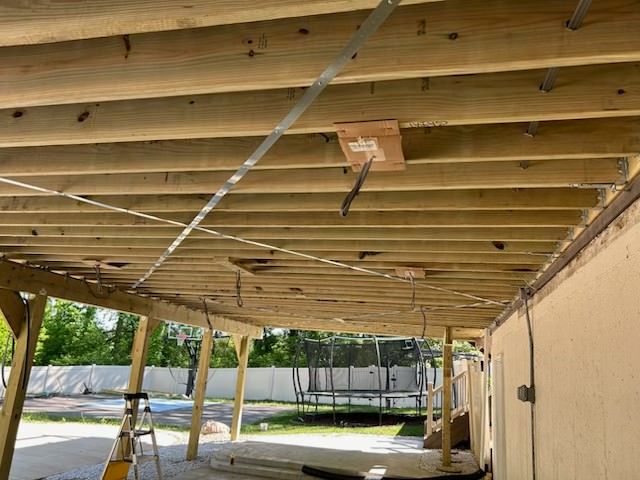 A wooden deck under construction with a ladder in the background