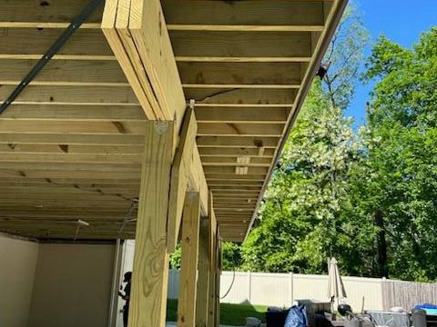 A wooden deck is being built in a backyard.