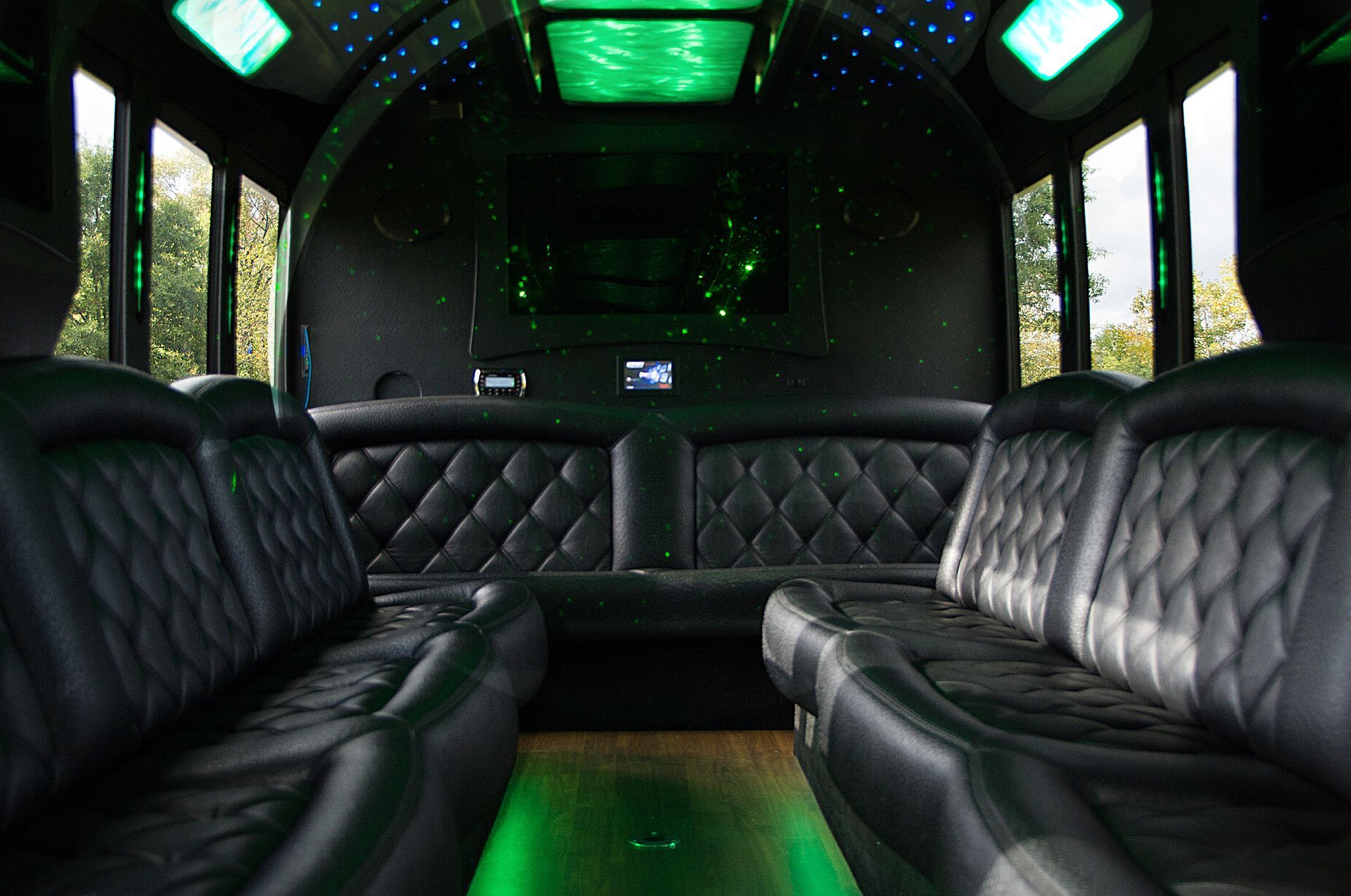Luxury limousine interior with black leather seats and green ambient lighting
