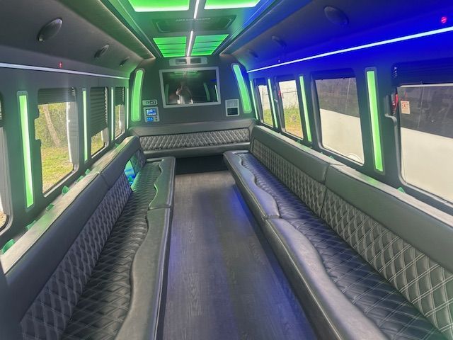 Empty luxury van interior with quilted leather benches and neon green-blue lighting