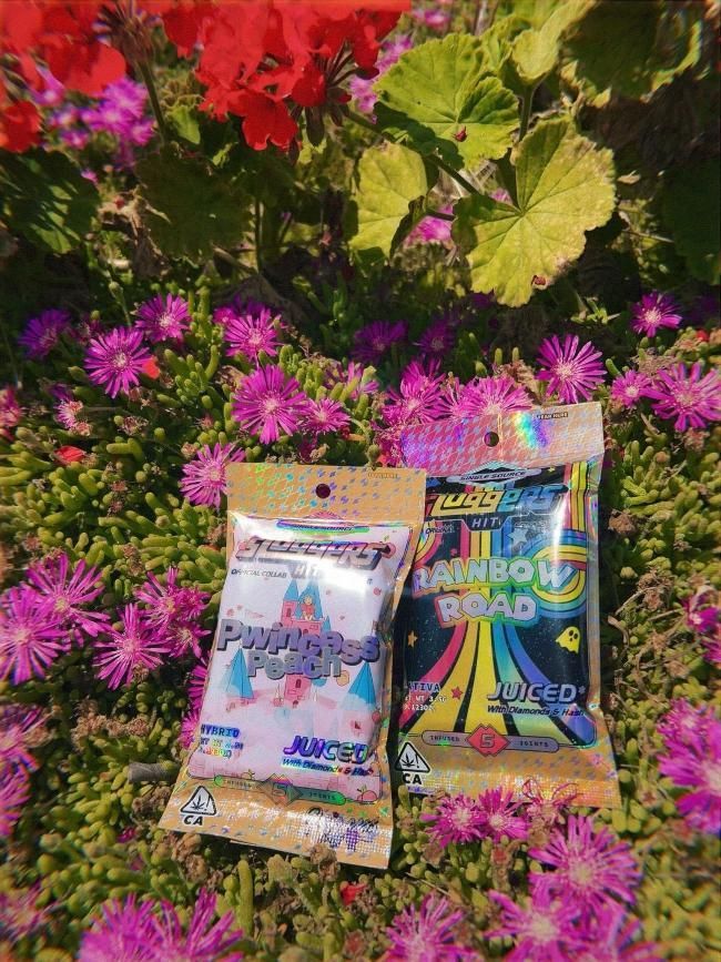 Two bags of candy are sitting in a field of flowers.