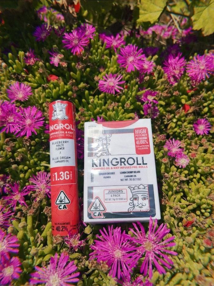 A package of king roll sitting on top of a pile of purple flowers.