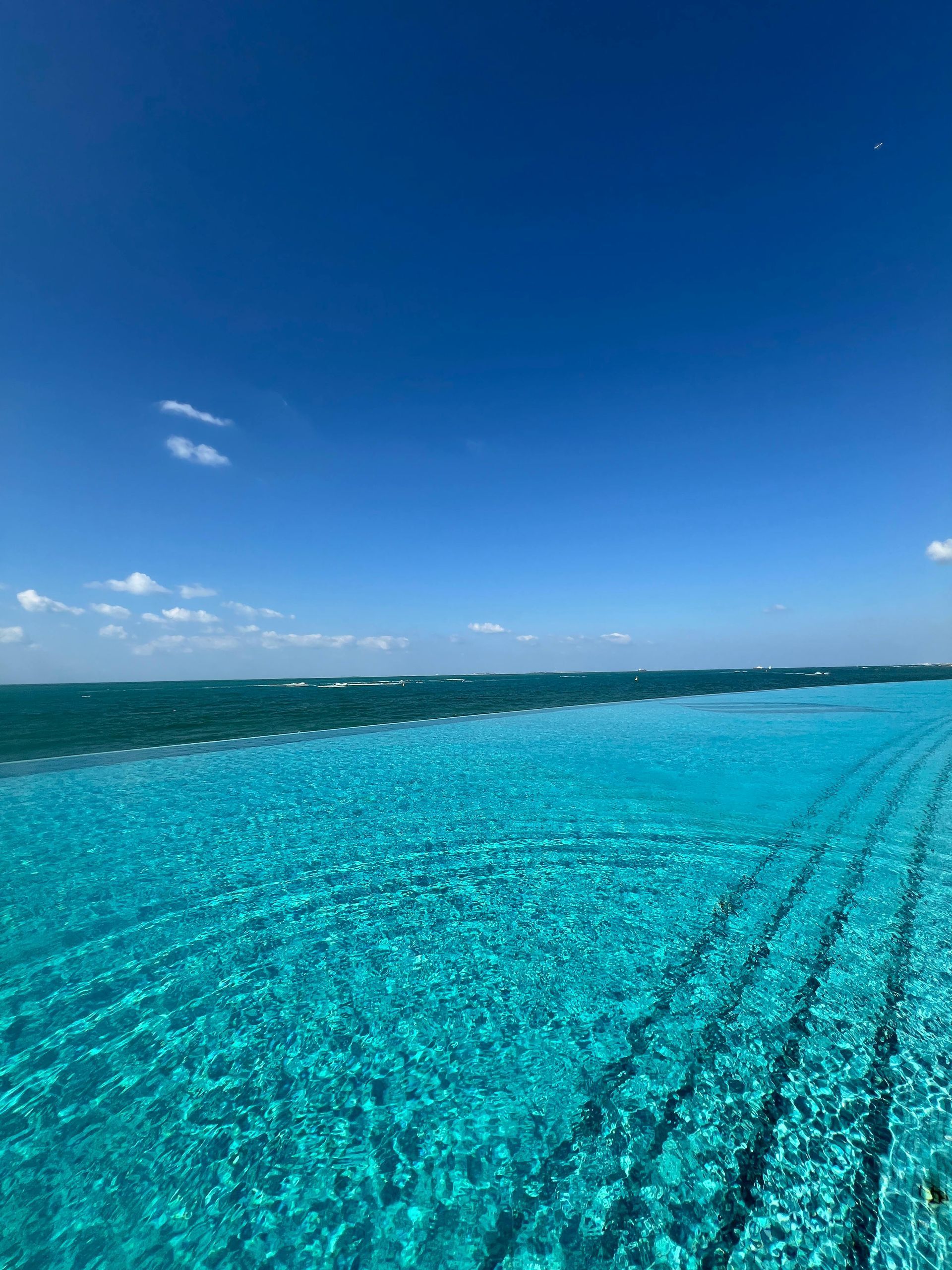 Turquoise ocean under a clear blue sky, with rippled water and a distant horizon