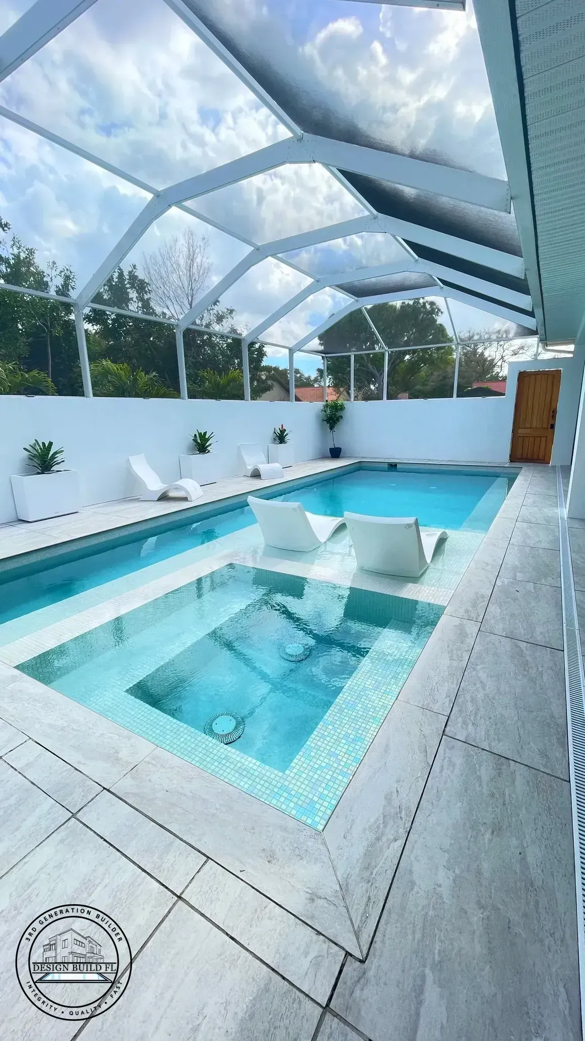 Enclosed outdoor pool with clear blue water, white deck, and screened roof under a bright sky