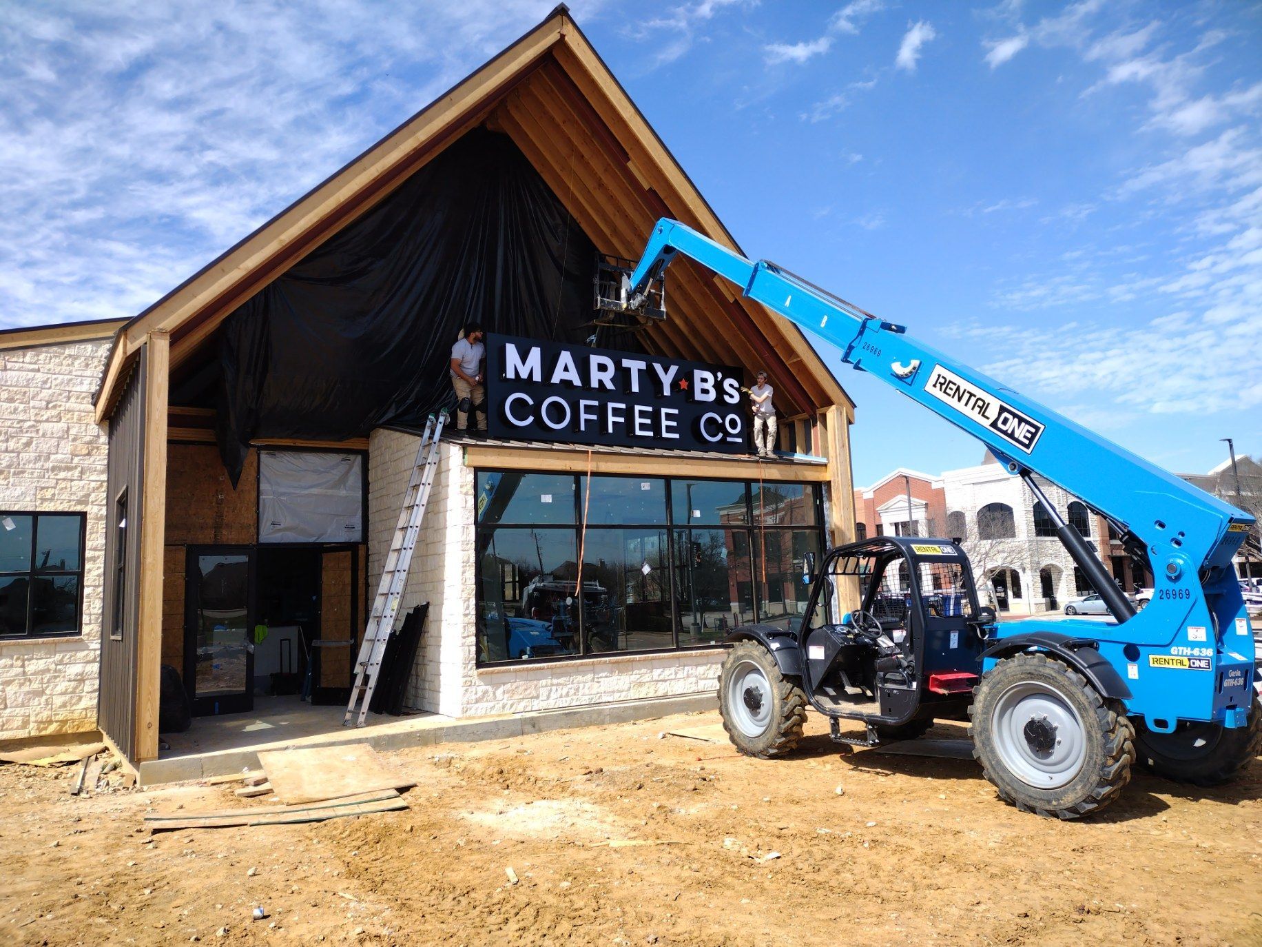 Front-lit channel letter building sign on backplate being installed at Marty B's Coffee Co in Bartonville, TX