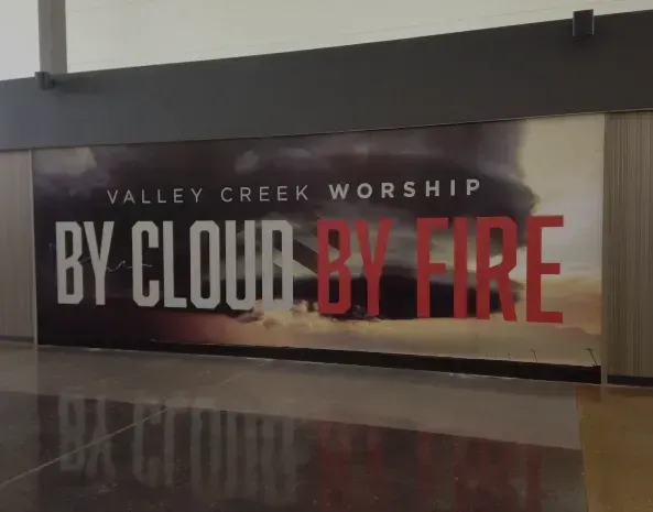 a sign for valley creek worship says by cloud by fire