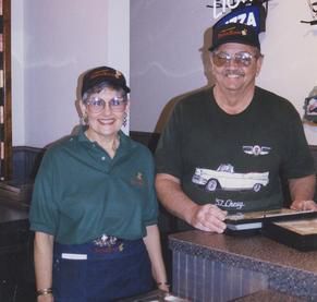 A man and a woman standing next to each other in a restaurant