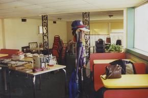 A person standing in a diner with tables and chairs