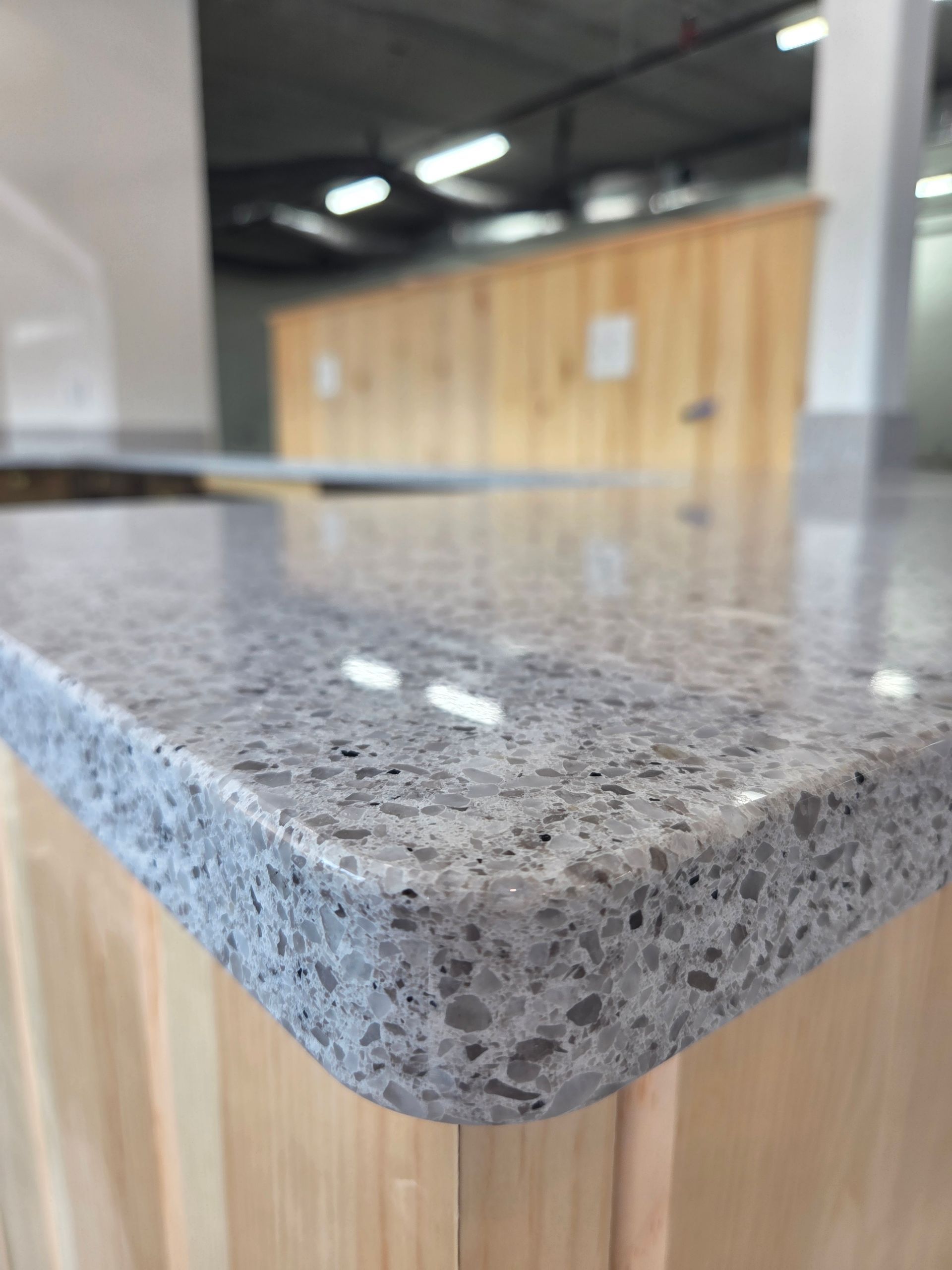Close-up of a speckled gray granite countertop with a rounded edge in a modern kitchen.