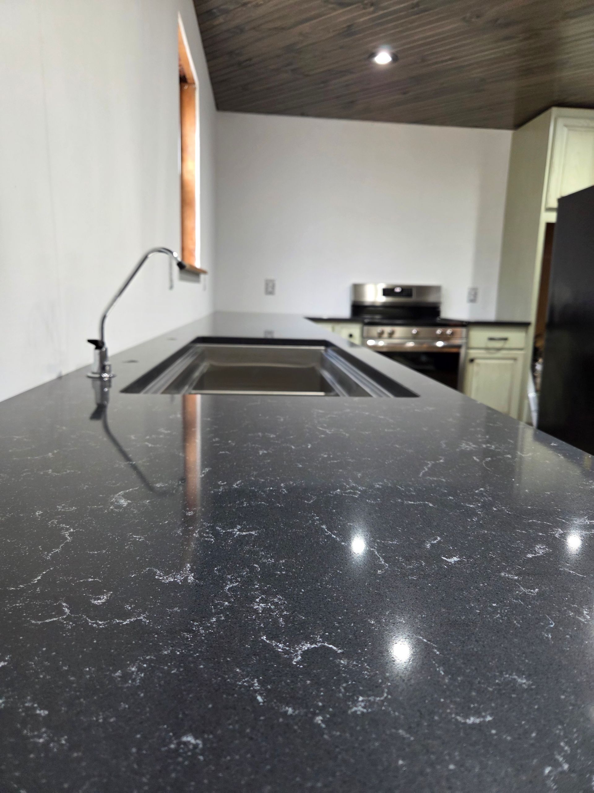 Modern kitchen with black speckled countertop and stainless steel sink
