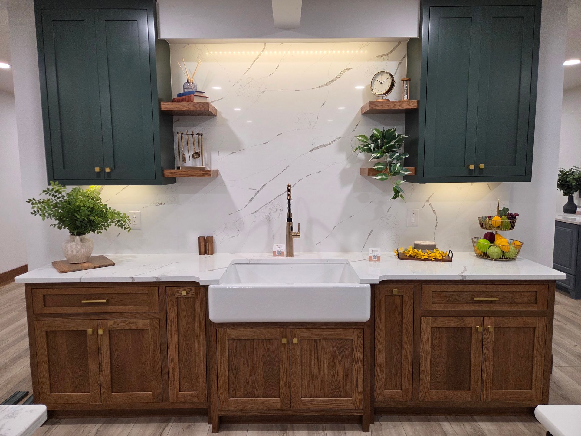 Modern kitchen with dark cabinets, white marble backsplash, farmhouse sink, and wood lower cabinets