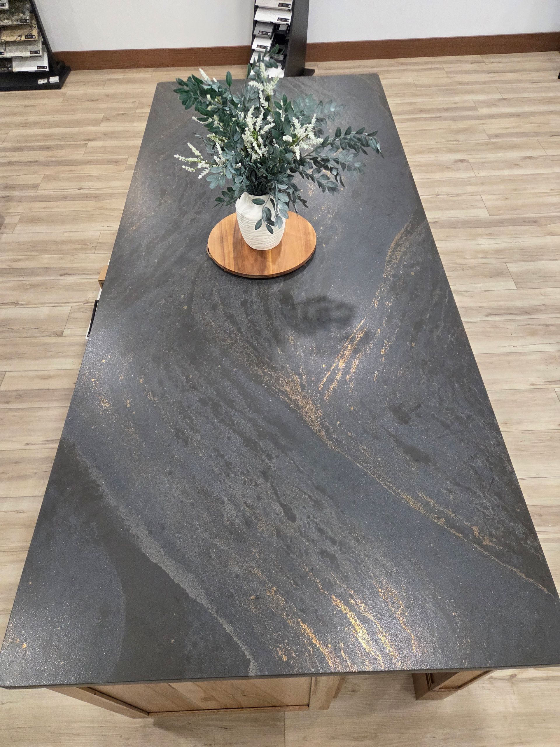 Black marbled coffee table with a small potted plant on top in a room with wood flooring
