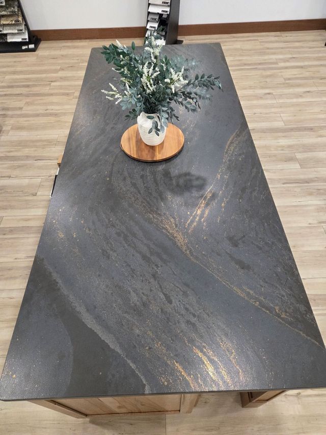 Dark stone dining table with a small potted plant centerpiece in a room