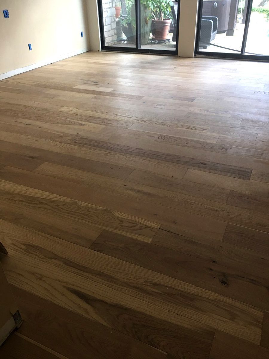 Empty room with light wood floors and sliding glass doors opening to a patio.