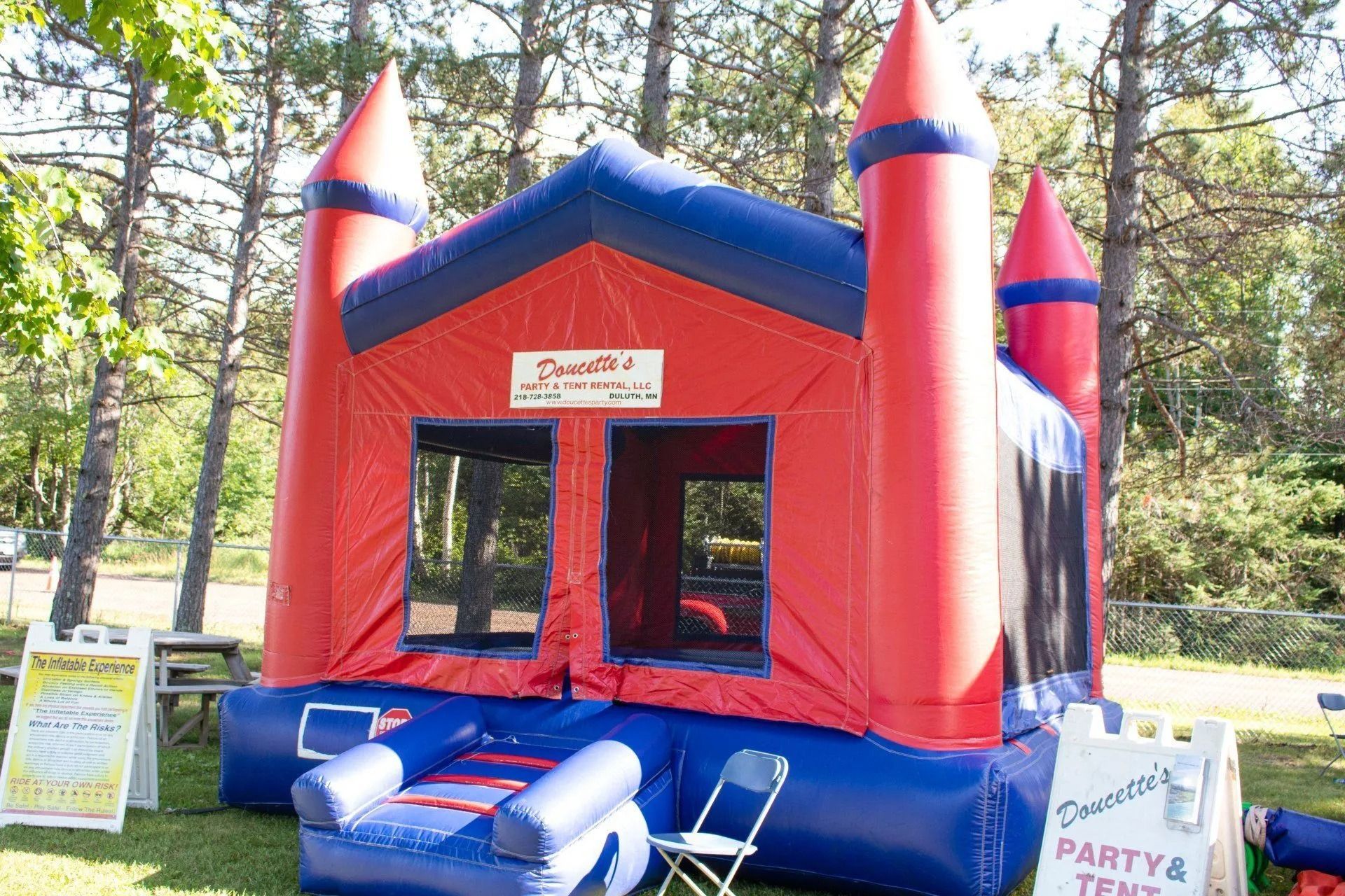 Red and blue inflatable bounce house in a grassy yard.
