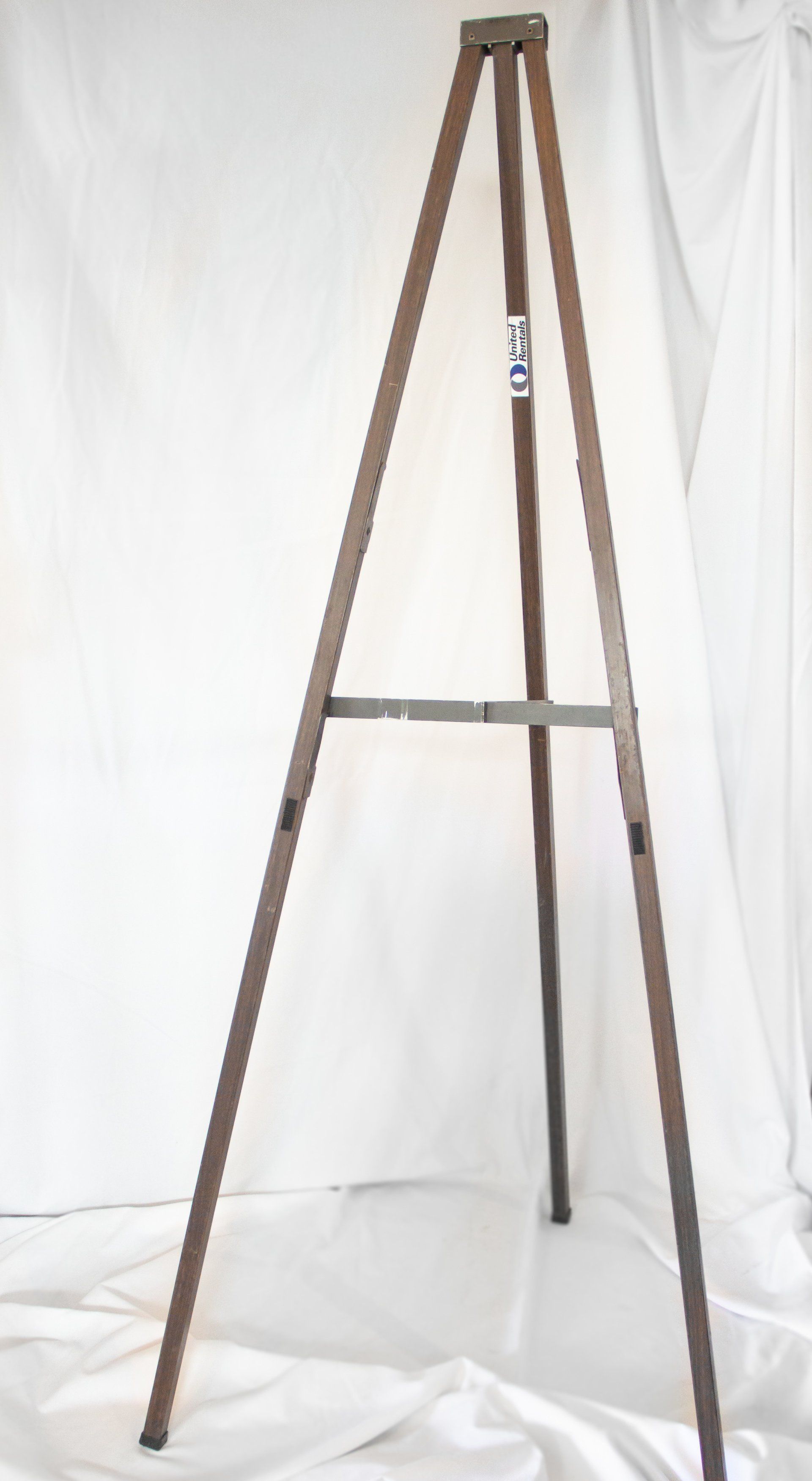 Brown metal easel on a white backdrop.