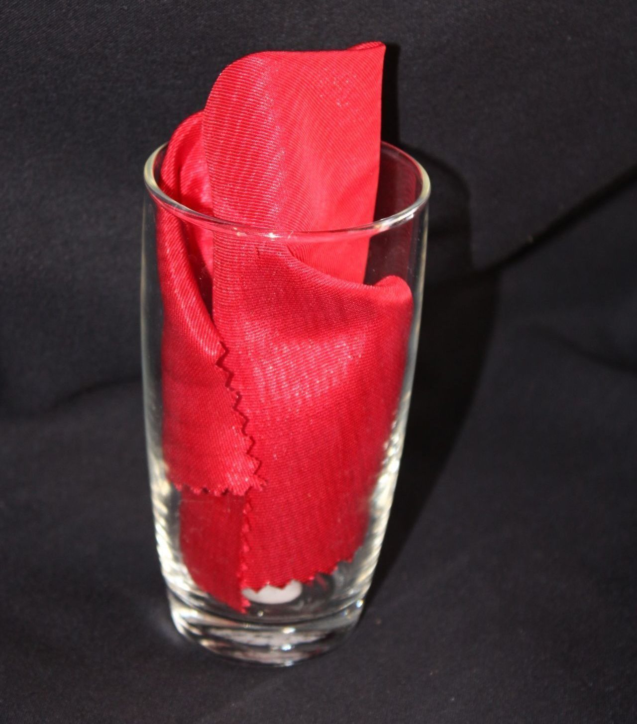 Red cloth napkin in a clear glass.