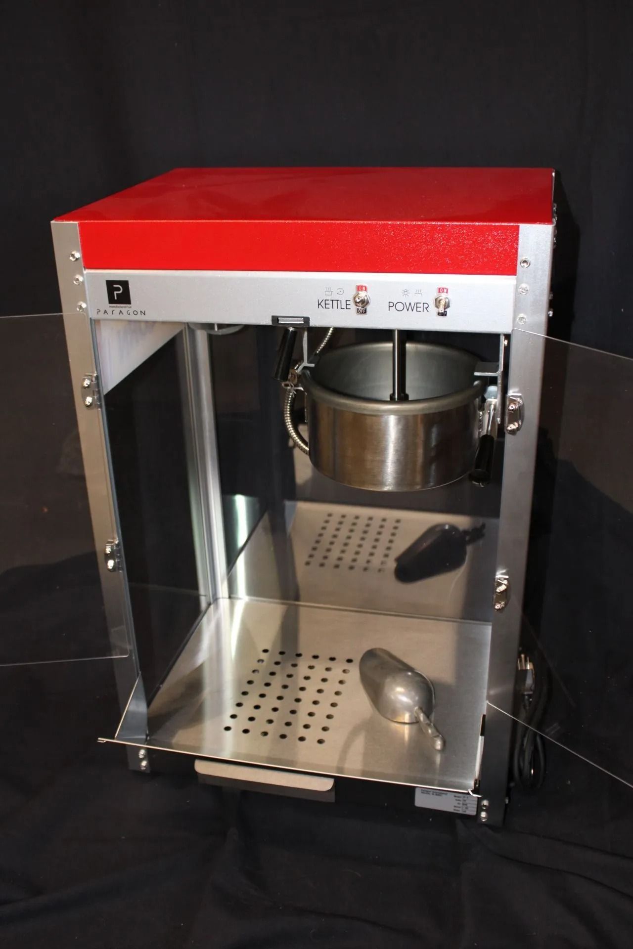 Popcorn machine, stainless steel and red, with a kettle and scoop.