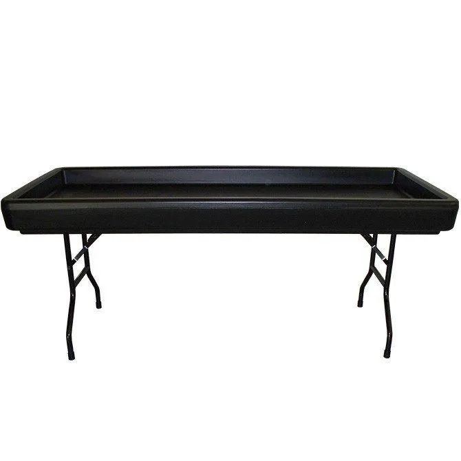 Black rectangular table with built-in tub, supported by folding metal legs.