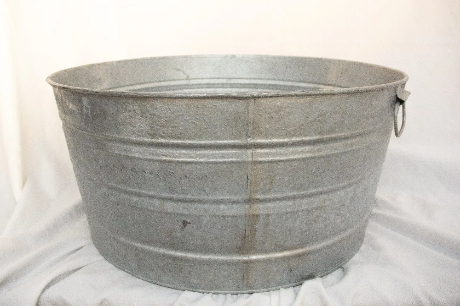 Metal washtub with rolled rim and horizontal bands.