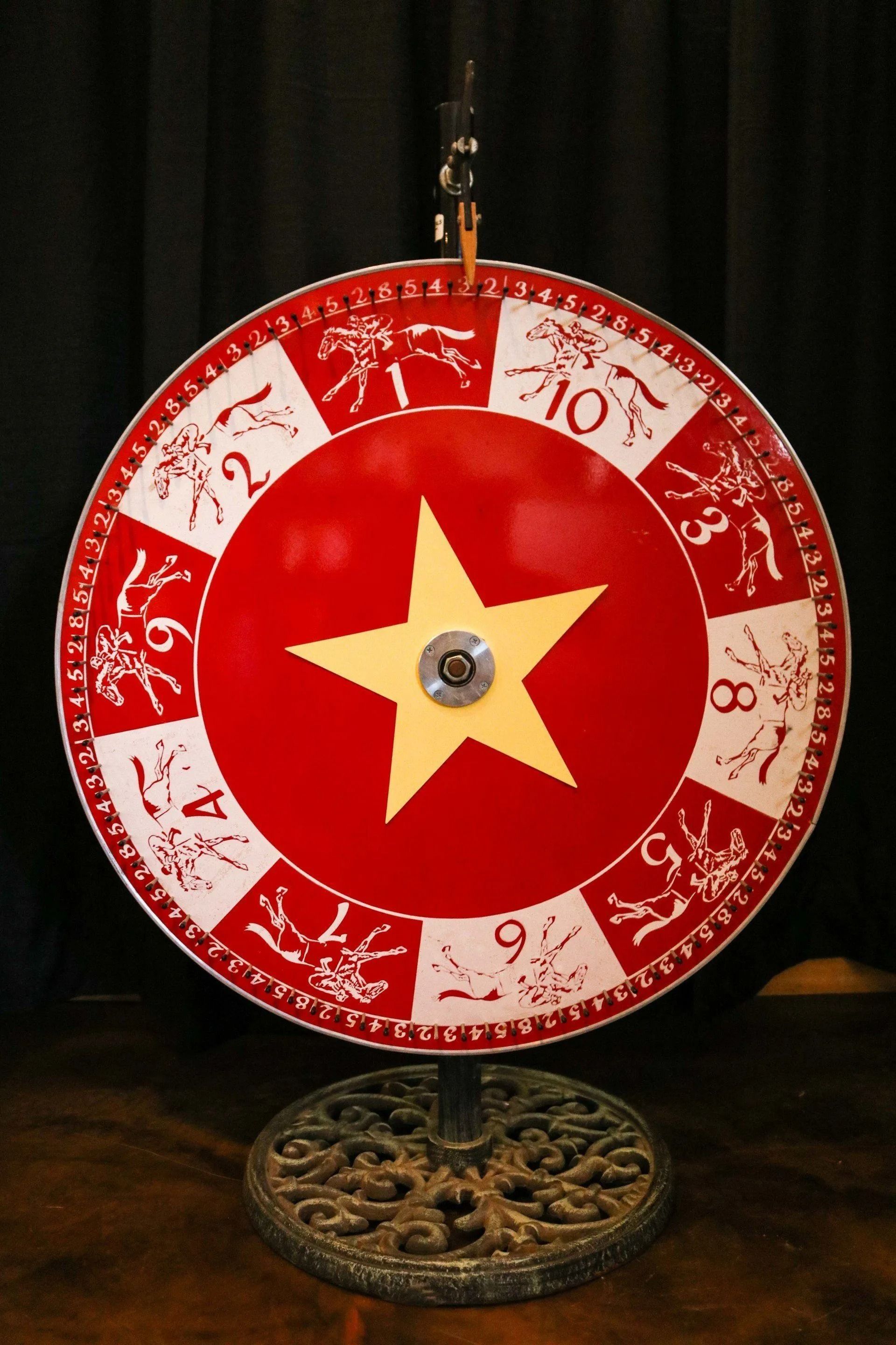 Red fortune wheel with a gold star in the center, and numbers and animal images around the edge.