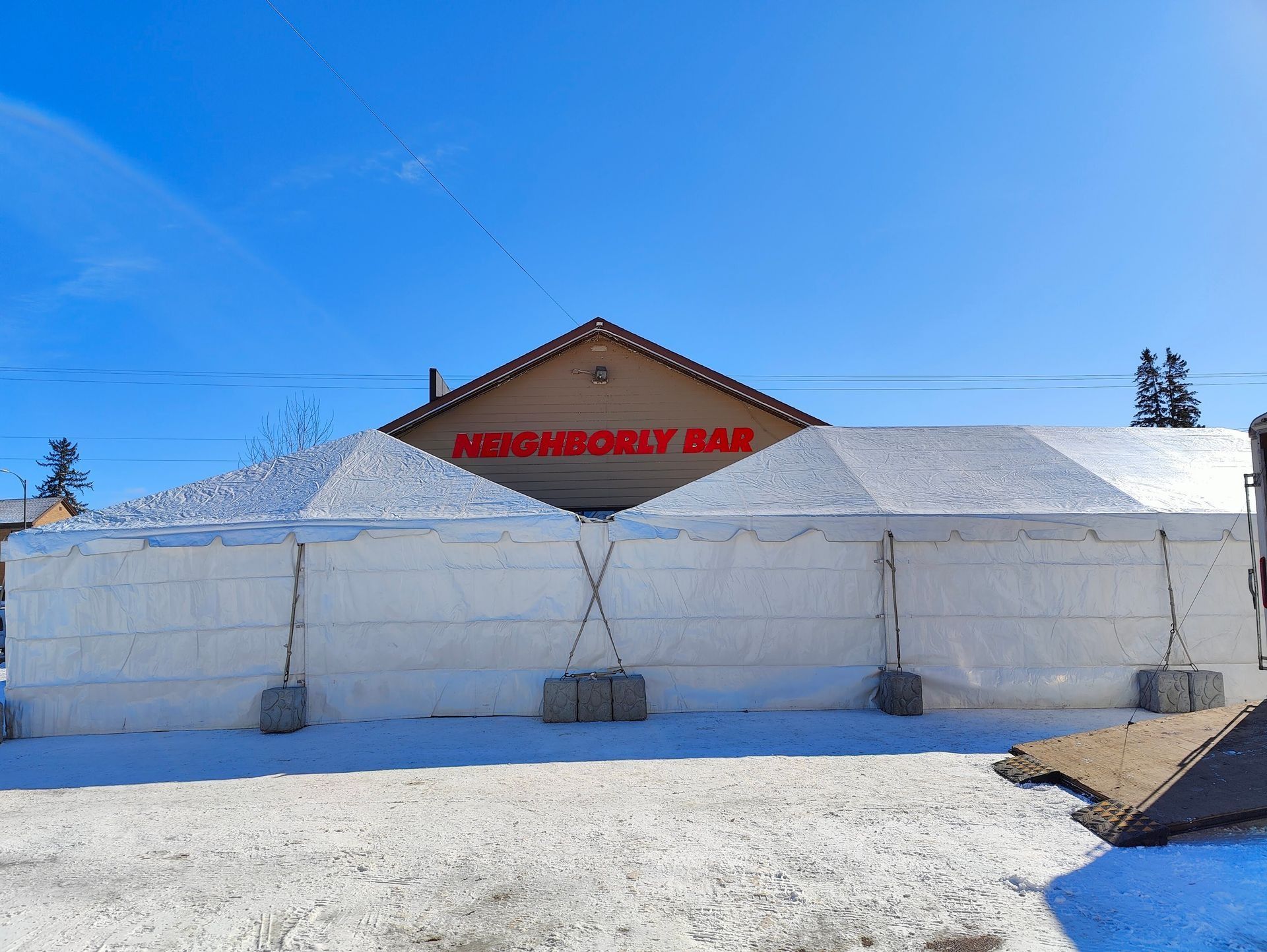 Two white tents in front of 