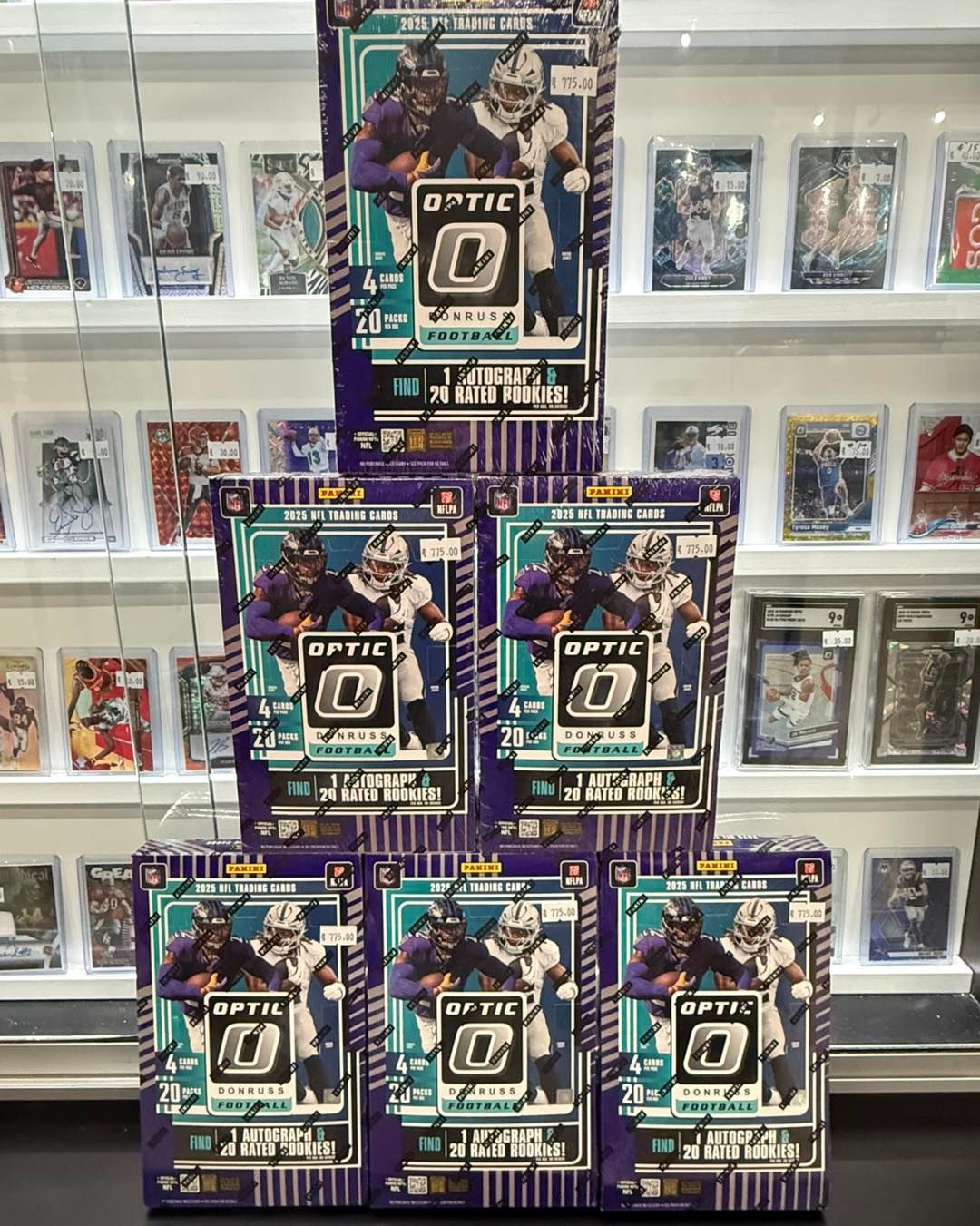 Stacked purple-and-teal Optic trading card boxes displayed on shelves in a store.