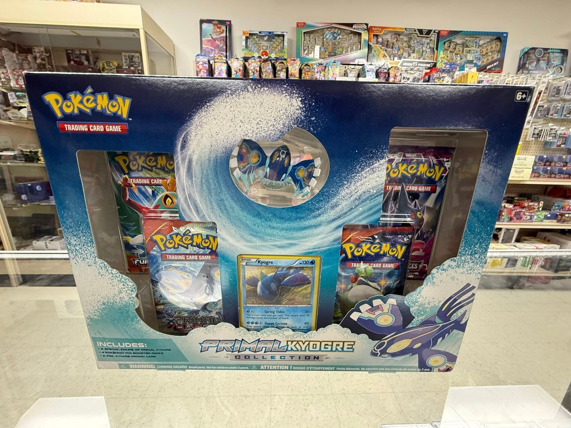 Pokémon Trading Card Game gift box with blue snowy artwork and three booster packs displayed in a store