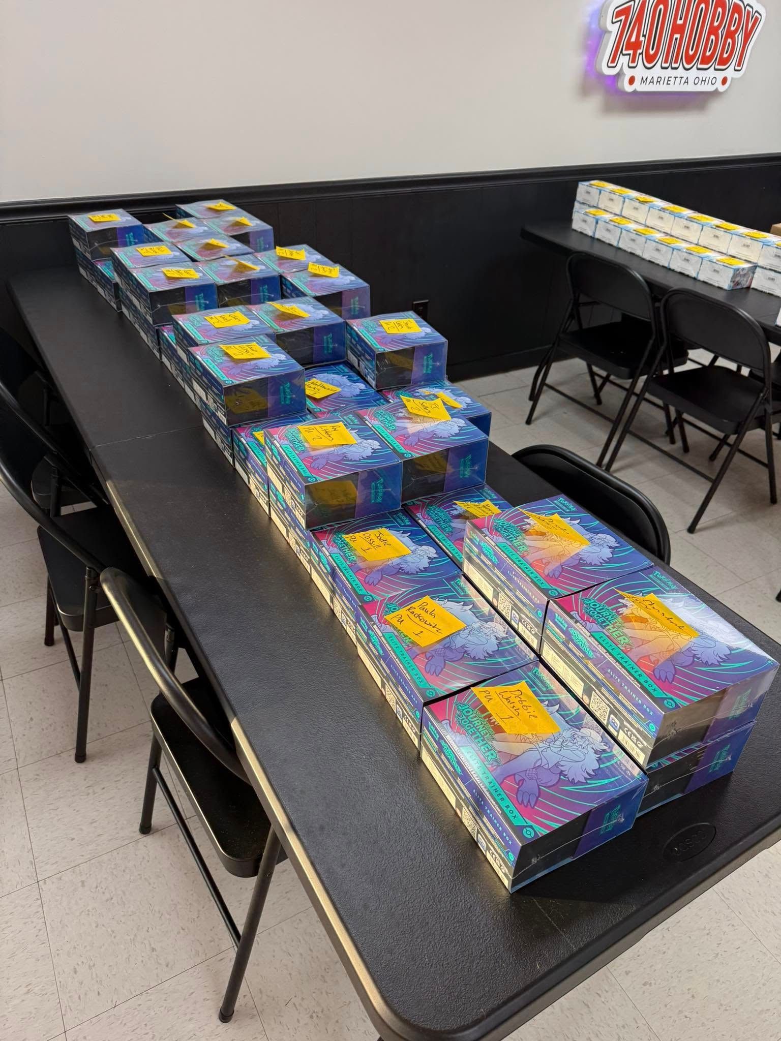 Tables covered with colorful wrapped gifts in a classroom or event room, arranged in rows.