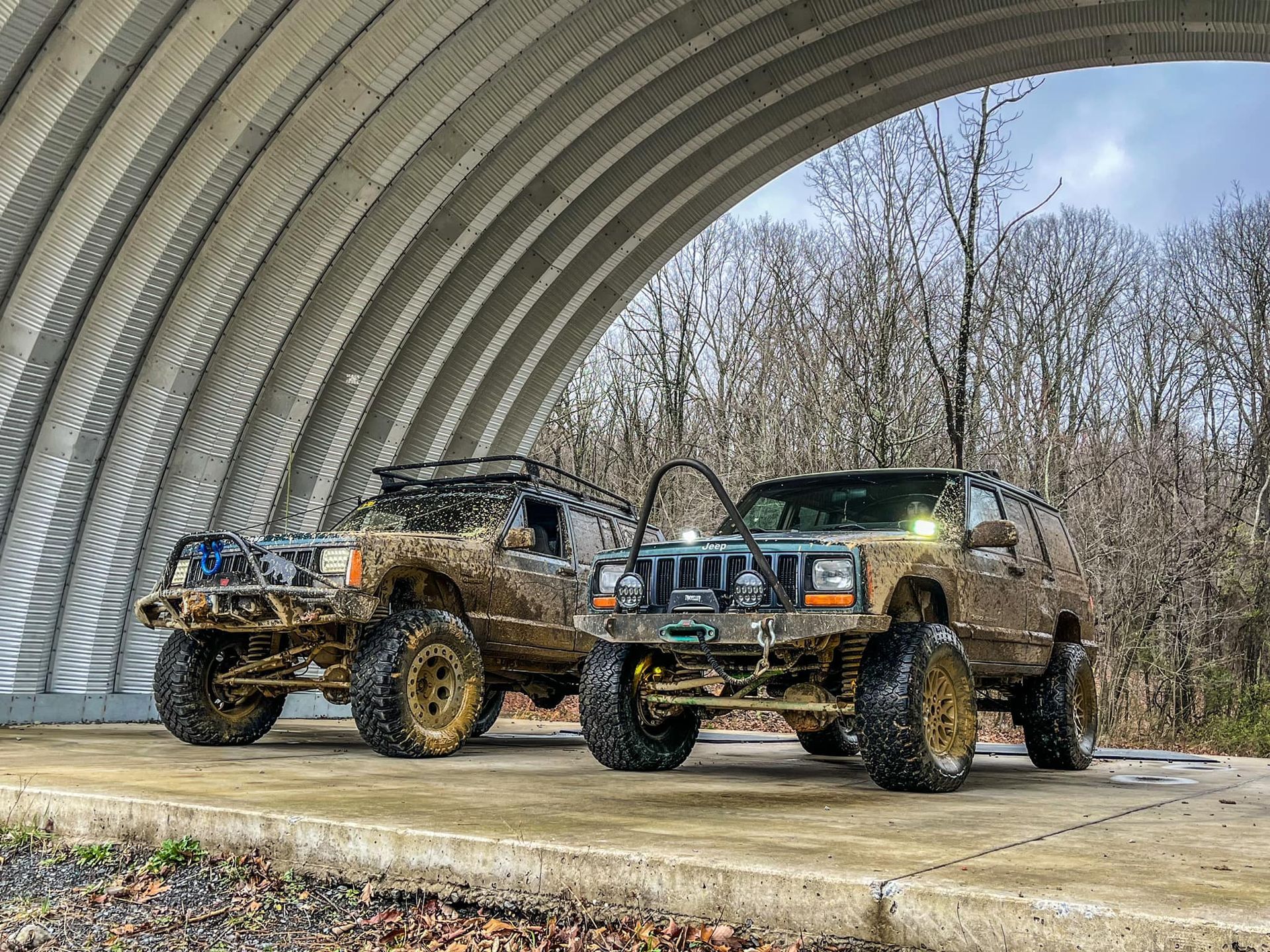 Two jeep parked under a metal archway