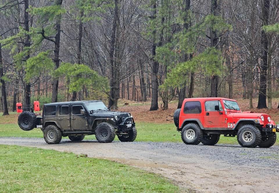 Two jeep parked next to each other on a dirt road