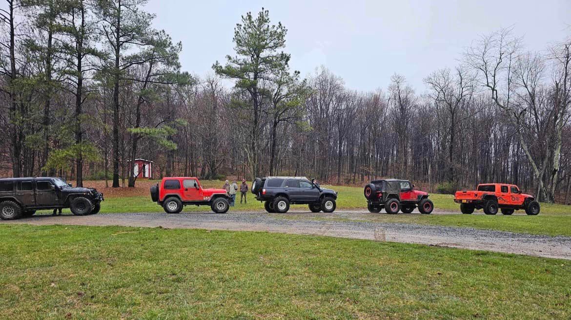 A group of jeep parked in a grassy field