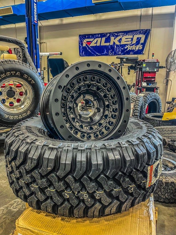 a pile of tires and wheels are stacked on top of each other in a garage