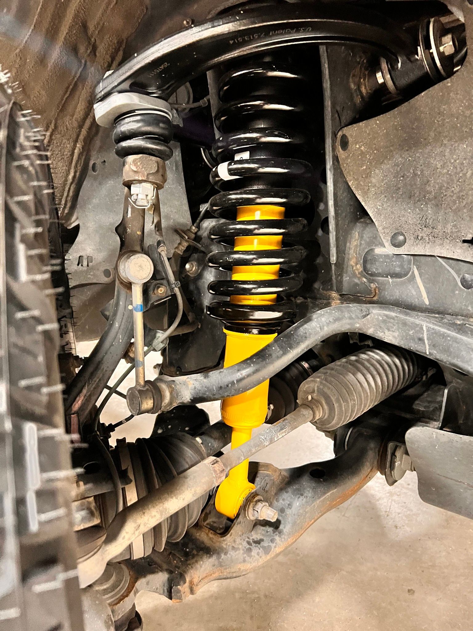 a close-up of a yellow shock absorber on a car