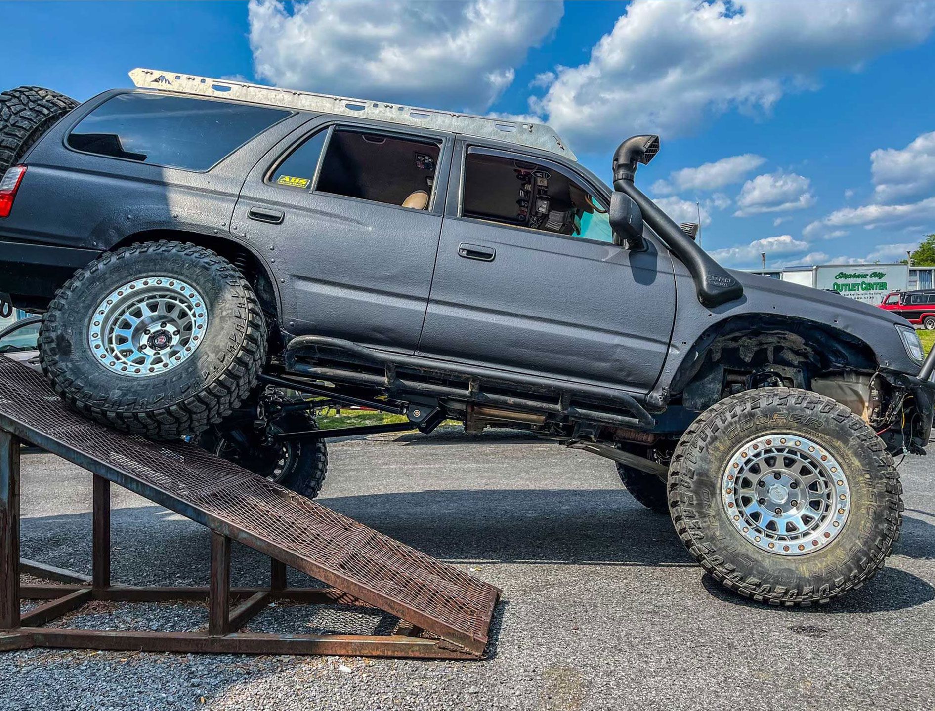 off-road truck with one tire on a ramp