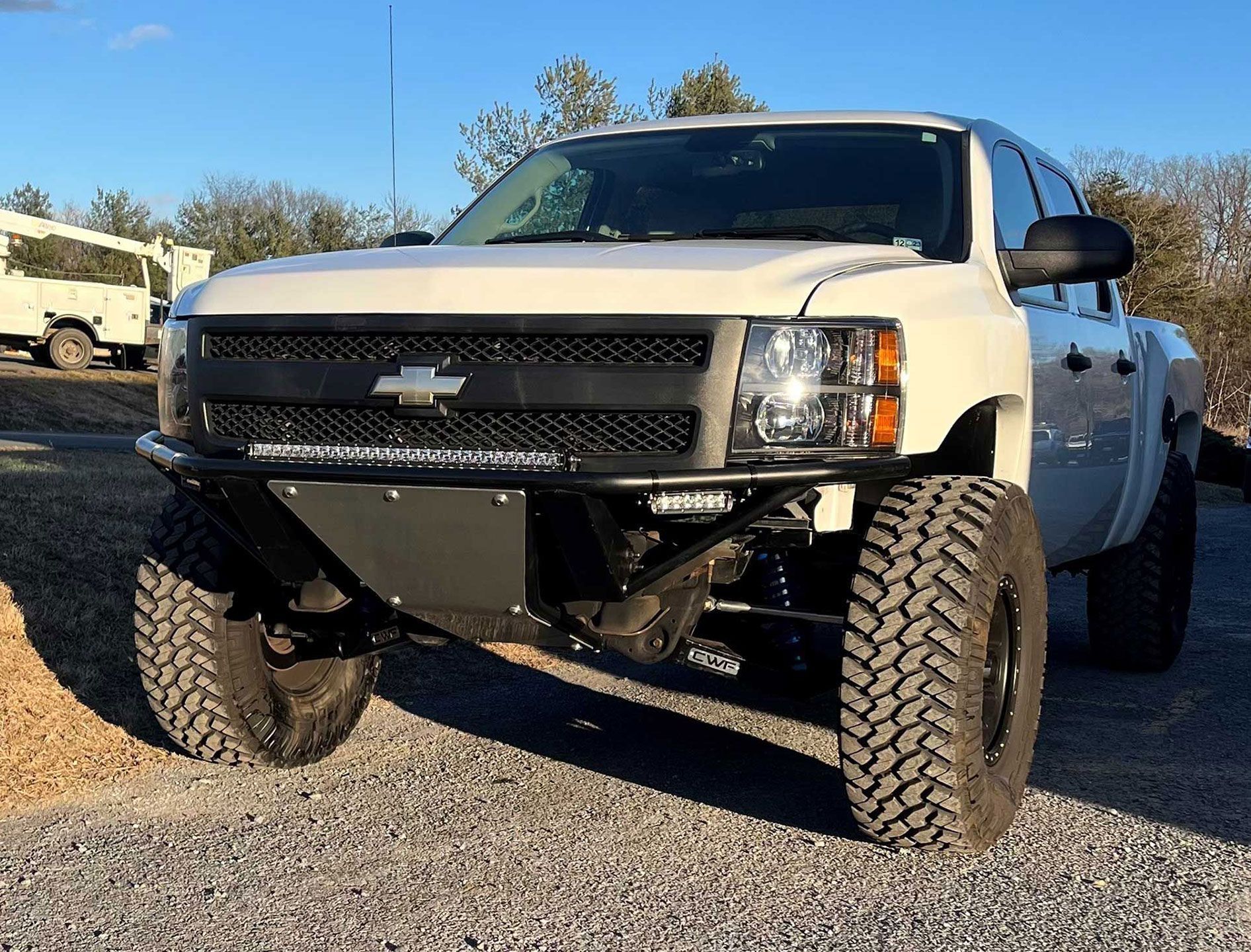 white Chevy pickup truck with huge tires