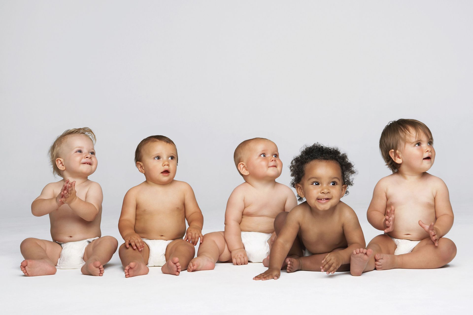 a group of babies are sitting in a row wearing diapers
