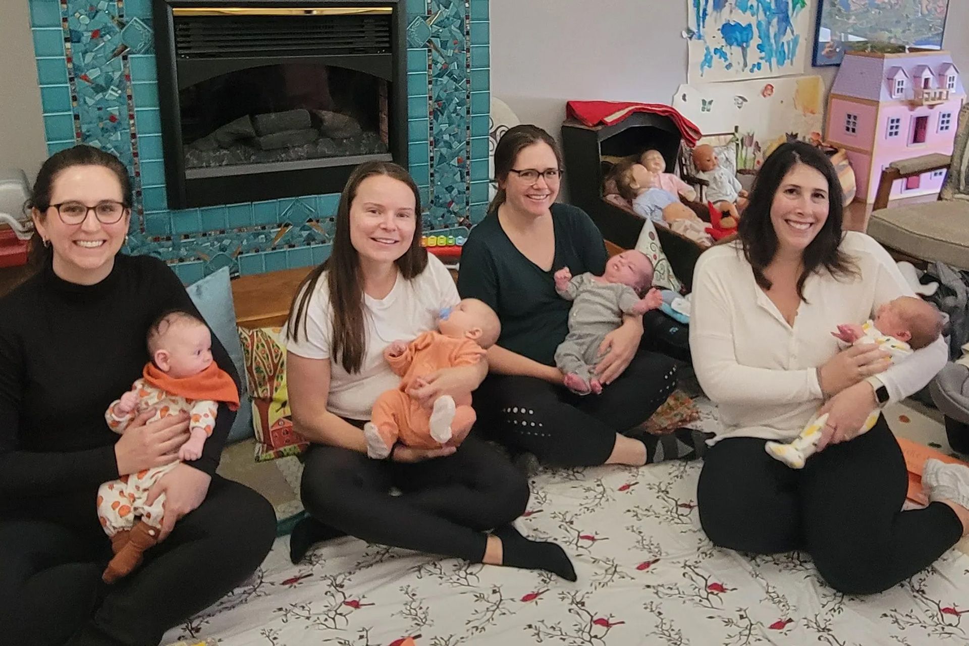 a group of women are sitting on the floor holding babies