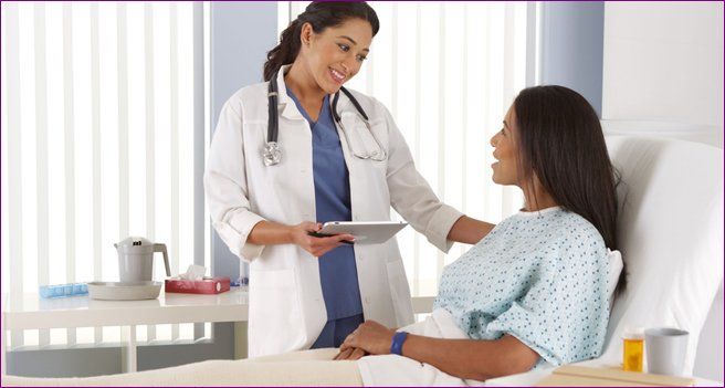 Hispanic female doctor talking to  patient