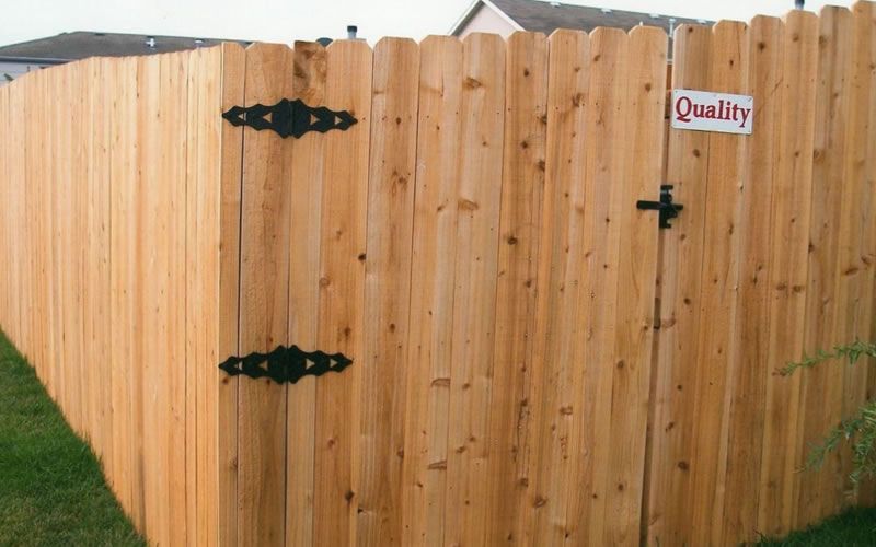 Wooden fence with gate, black hinges and latch, 