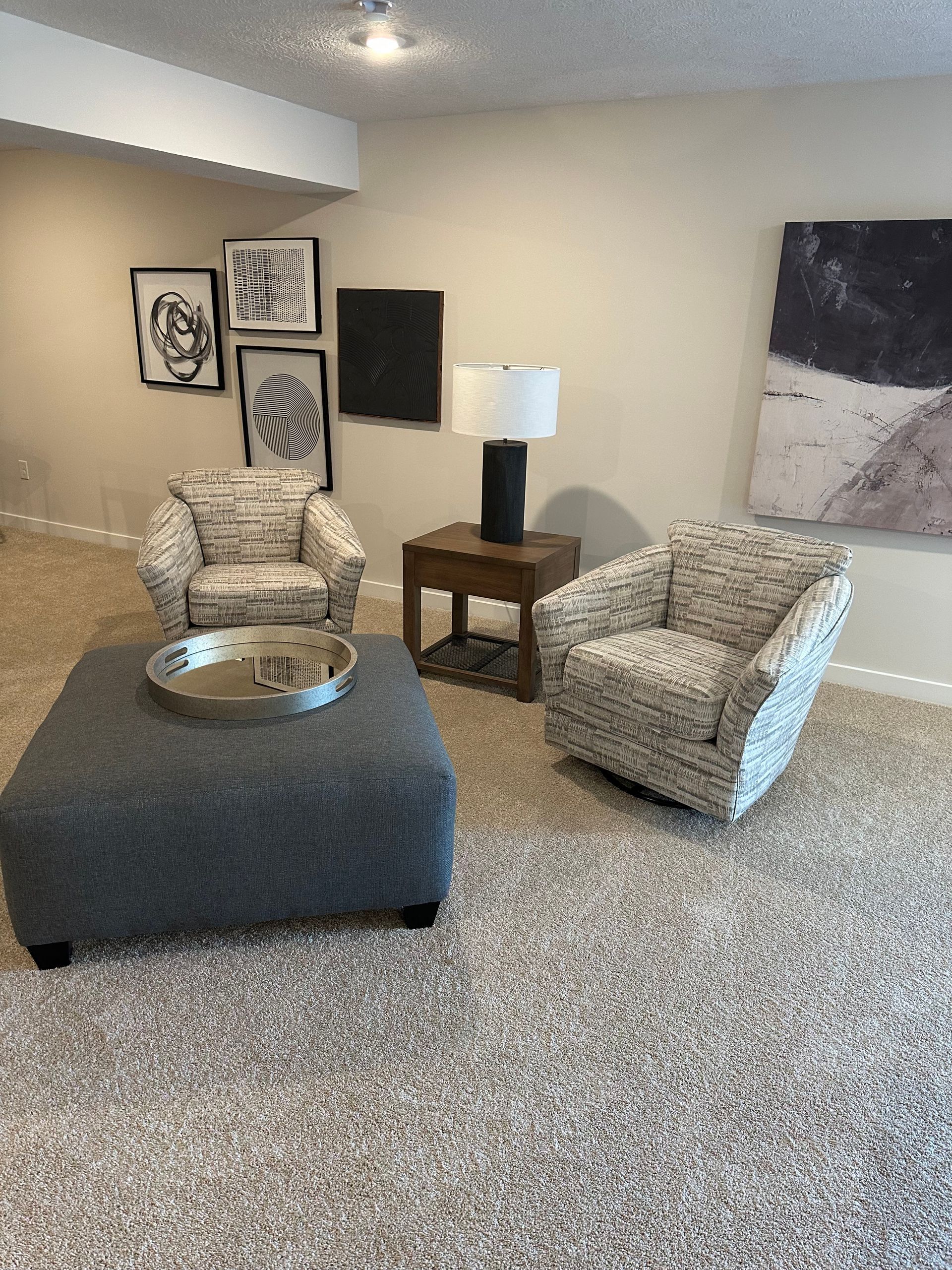 A living room with two chairs and an ottoman