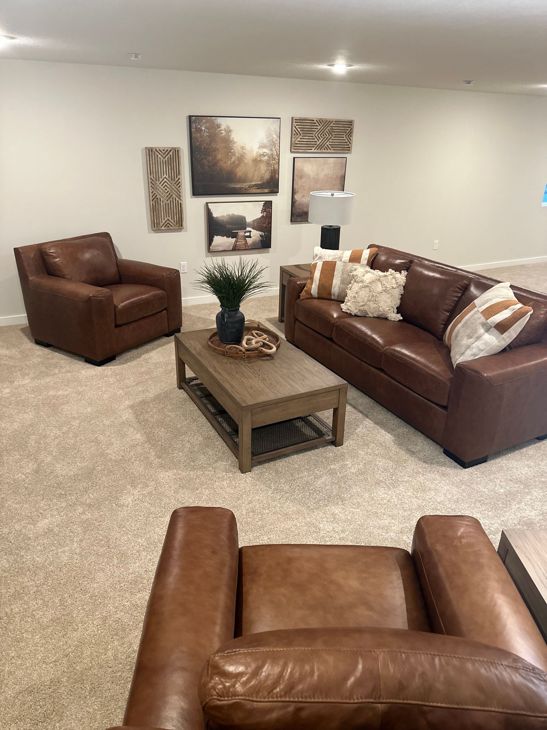A living room with a couch, two chairs, and a coffee table.