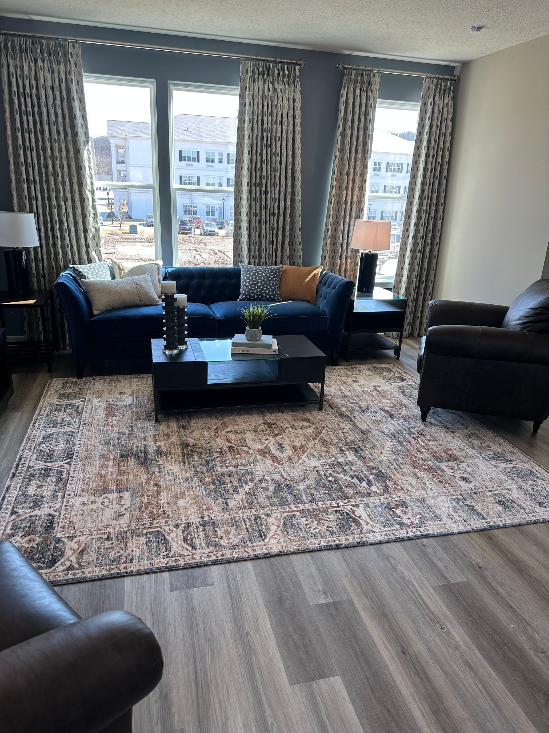 A living room with a couch, chair, coffee table, and rug.