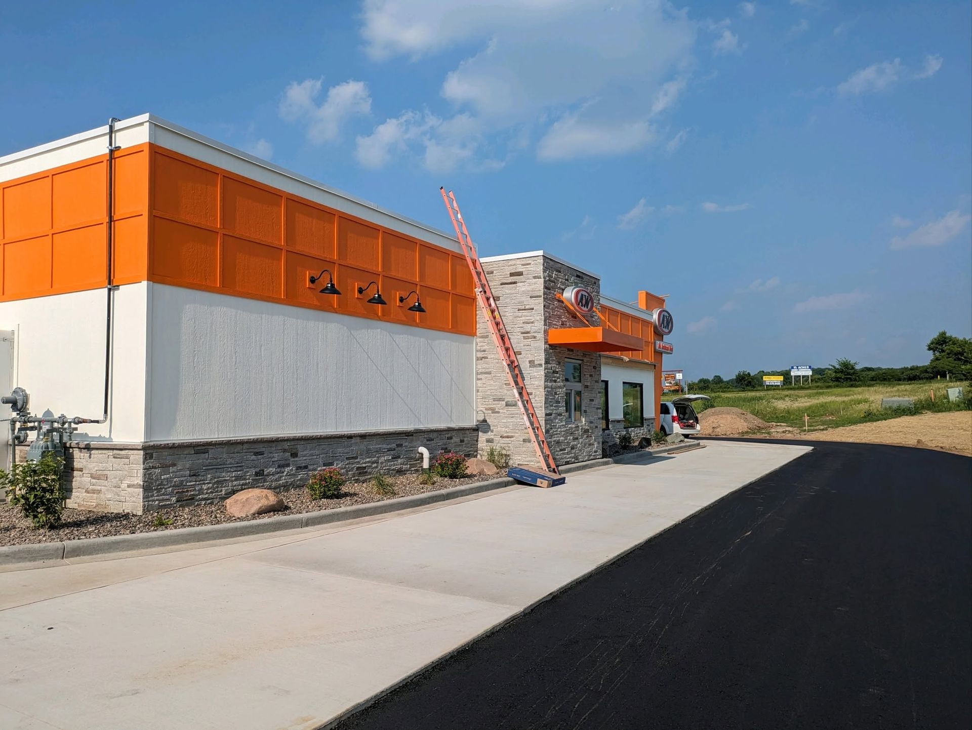 Orange-and-white building along a paved road under a clear blue sky.