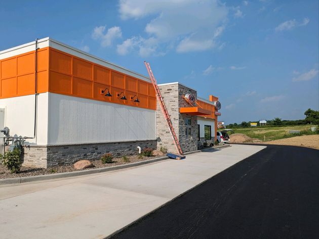 Orange-and-white building along a paved road under a clear blue sky.