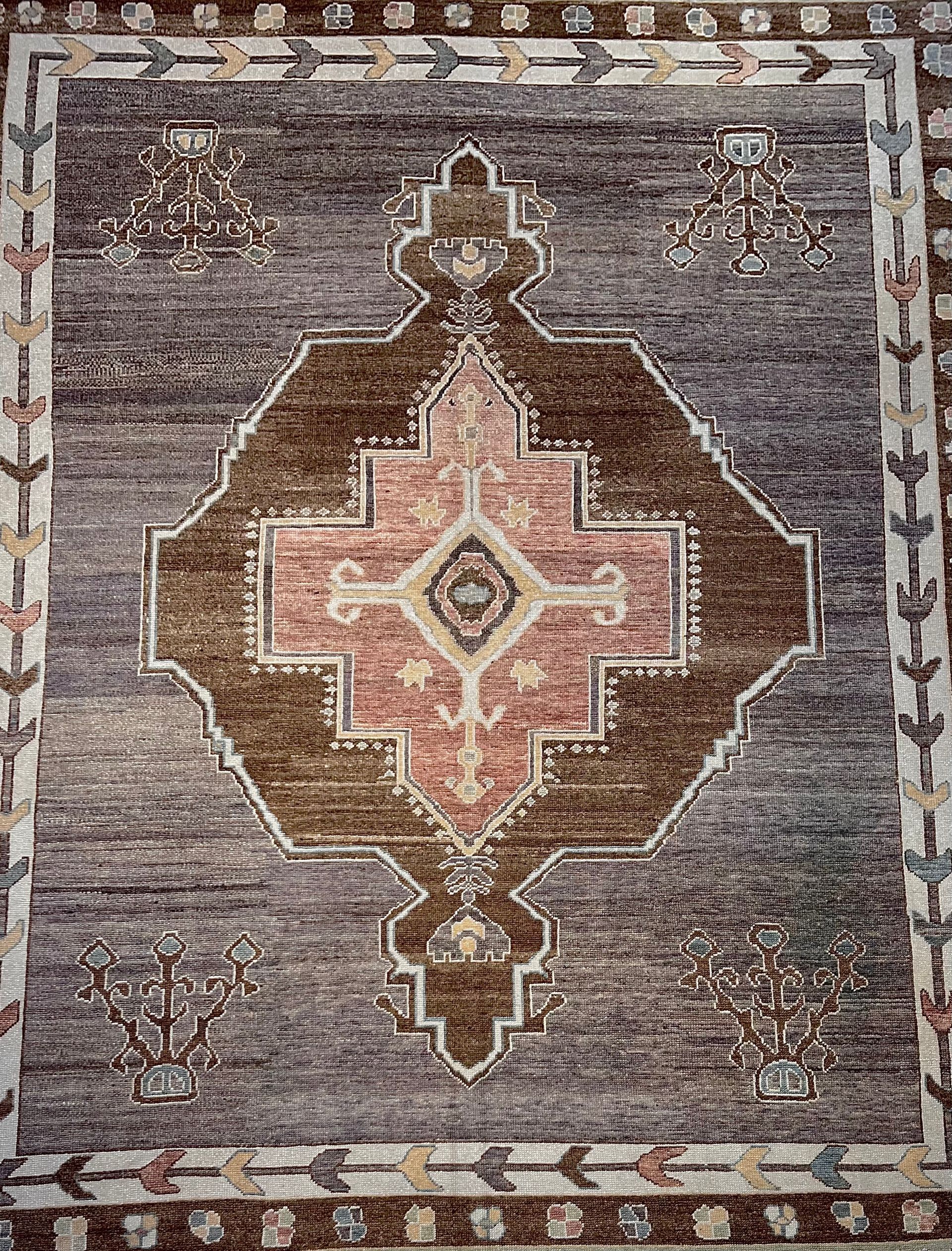 Brown and gray patterned rug with a central diamond-shaped design and border details.