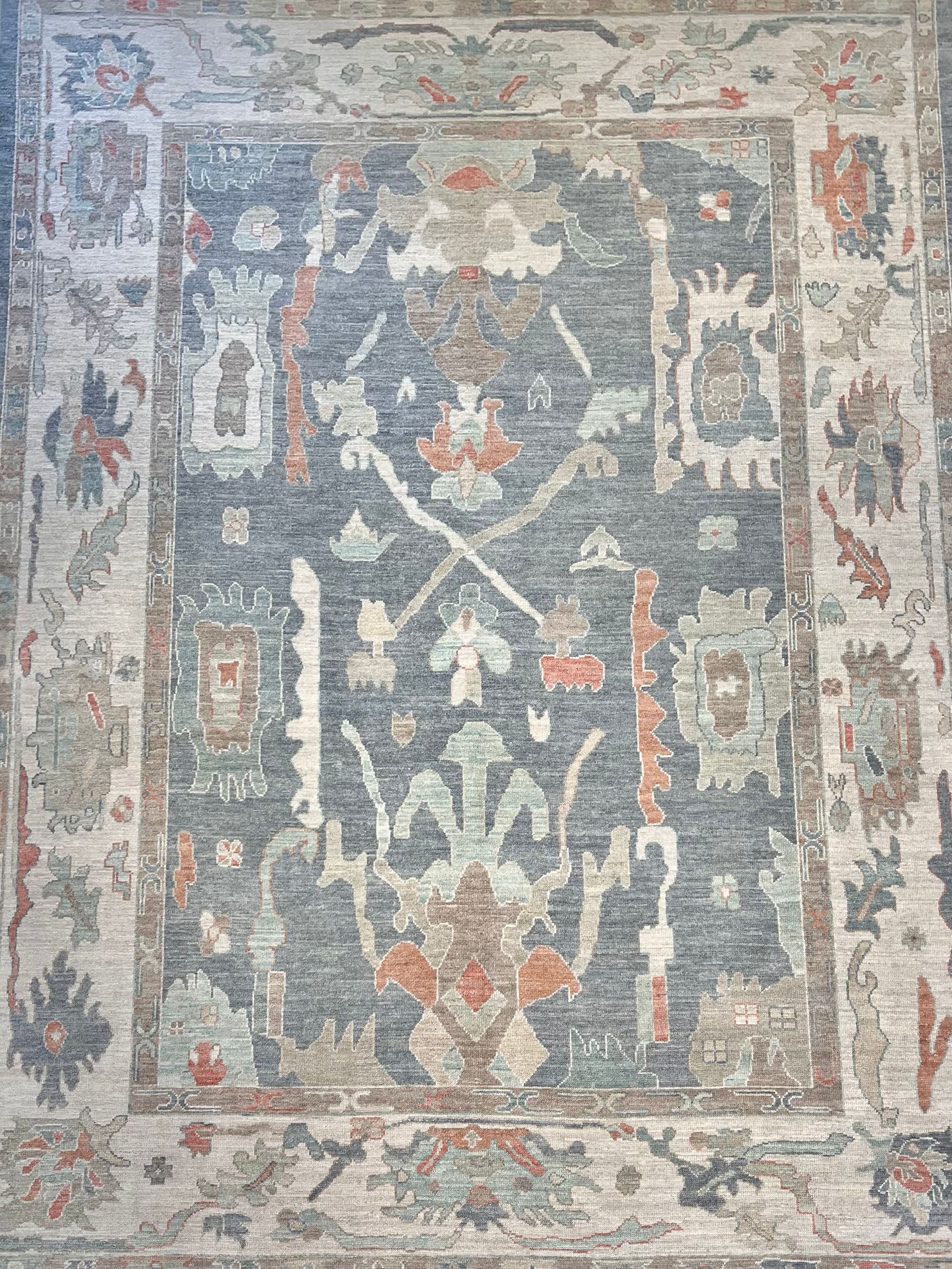 Blue and beige patterned area rug with floral and geometric motifs.